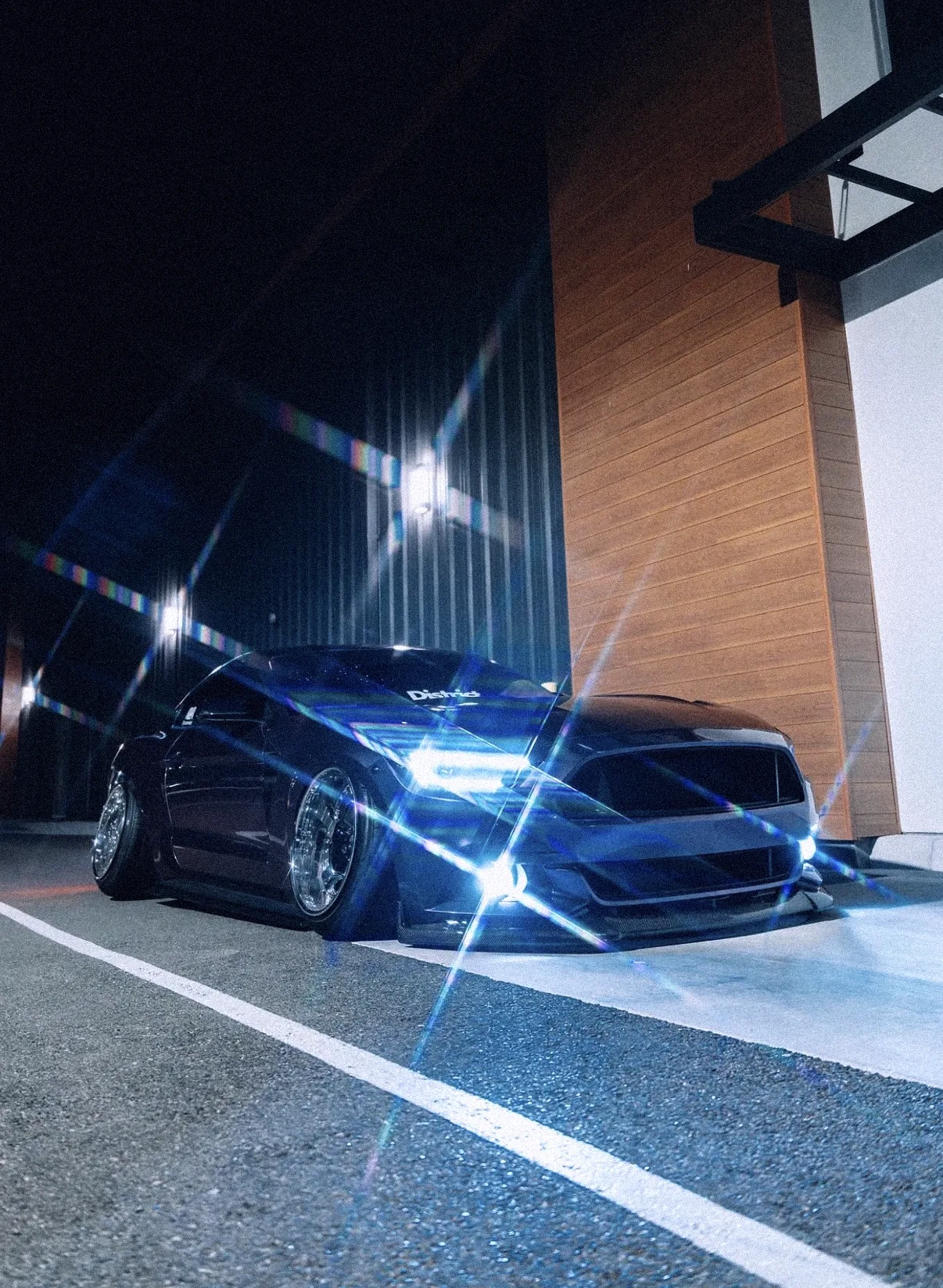 Purple Mustang at night with starburst headlights