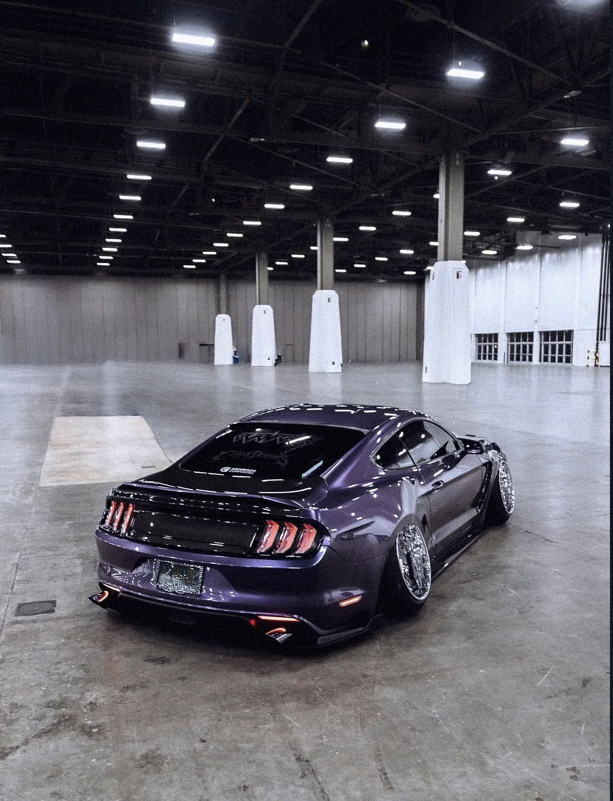 Purple Mustang from behind in an empty exhibition hall